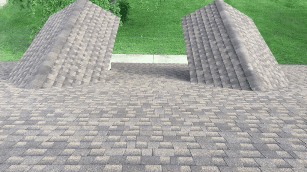 A rooftop by a top-rated roofing company features two triangular structures, creating an optical illusion of staircases leading upward. Grass and concrete form the backdrop, adding to the surreal effect.
