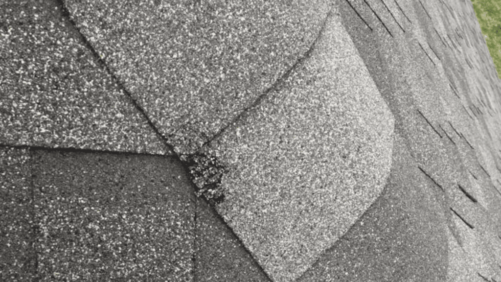 Close-up of asphalt roof shingles, some overlapping and showing a slight misalignment—perfect for those searching for top-notch remodeling near me.