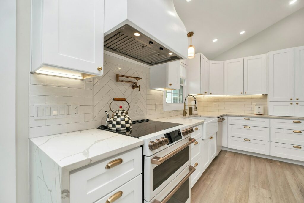 a kitchen with white cabinets and a stove top oven